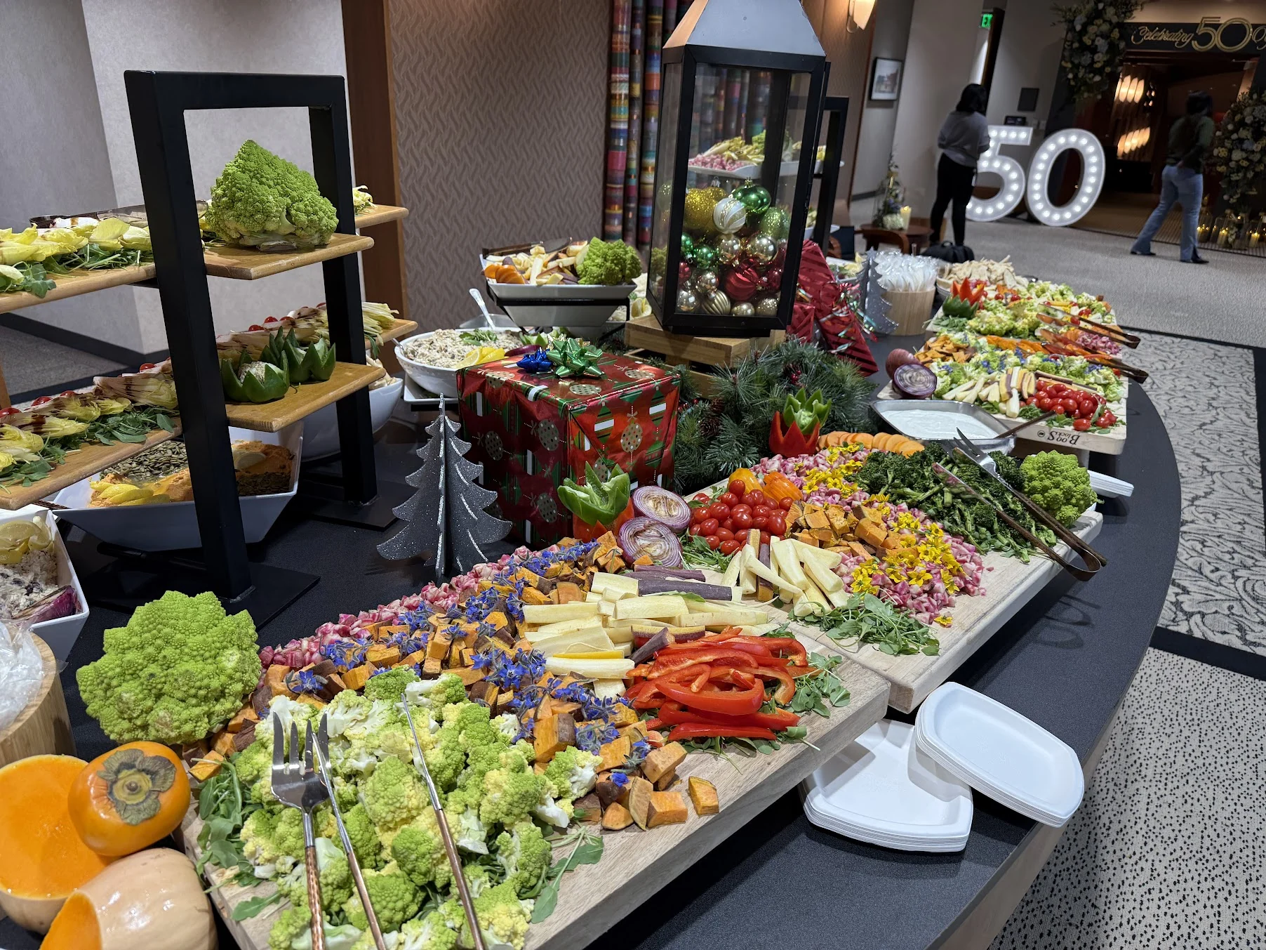 A large holiday grazing display with vegetables, salads, and seasonal decorations